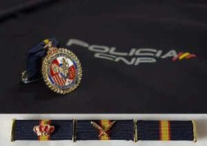 Medalla y pasador de diario sobre fondo de la Policía Nacional